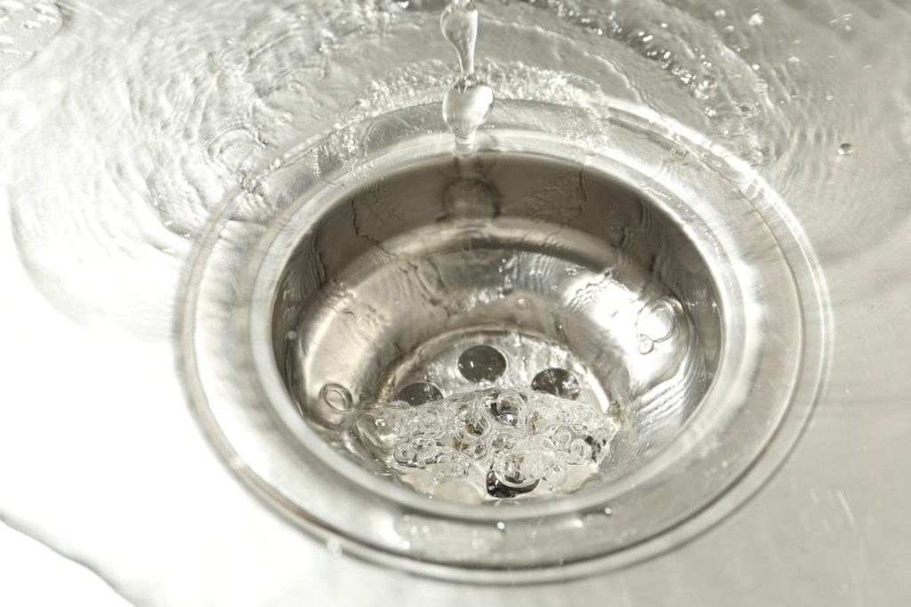 Clean water that meets tap water TDS standards going down a sink.