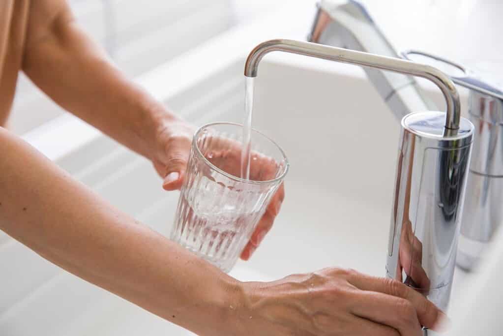 womans-hand-pouring-water-purifier-into