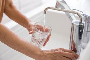 womans-hand-pouring-water-purifier-into